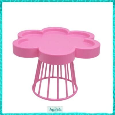 Mesa de centro rosa com design de flor, estrutura de base de barras metálicas.
